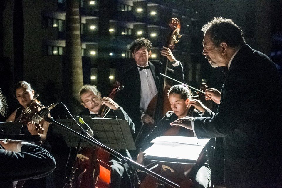 Mario Monroy dirige a un grupo de músicos durante un ensayo nocturno