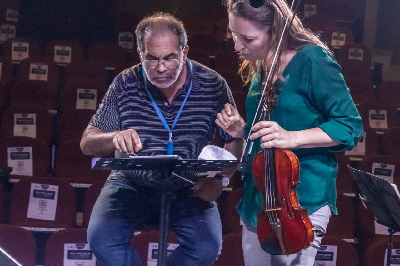 Mario Monroy revisa una partitura con una violinista