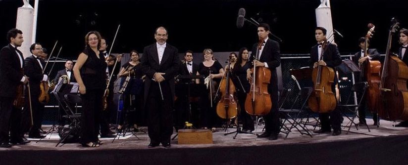 La orquesta de pie al final de un concierto